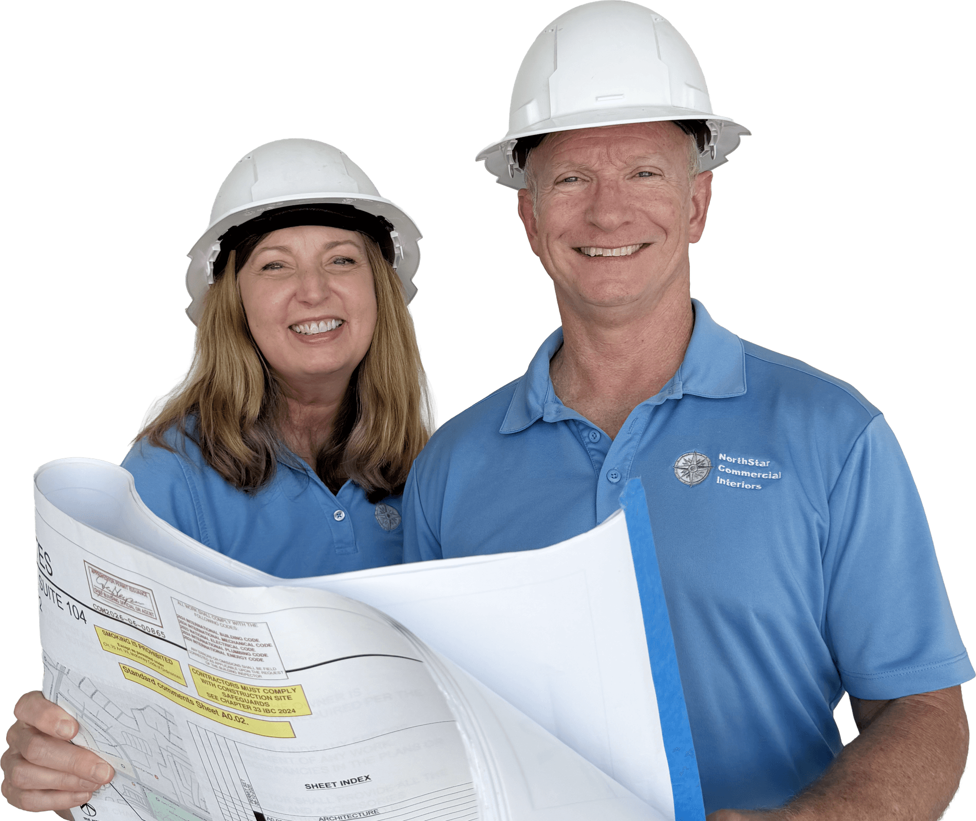 Jeff Hurst and Kristen Hurst, owners of NorthStar Commercial Interiors, in hard hats reviewing a set of construction drawings