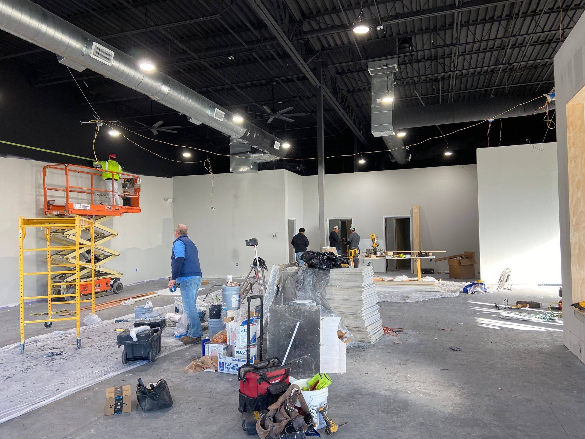 Progress: painting under way with the new ductwork, lighting and ceiling fans hung at Kung Fu Academy of North Texas in McKinney, TX