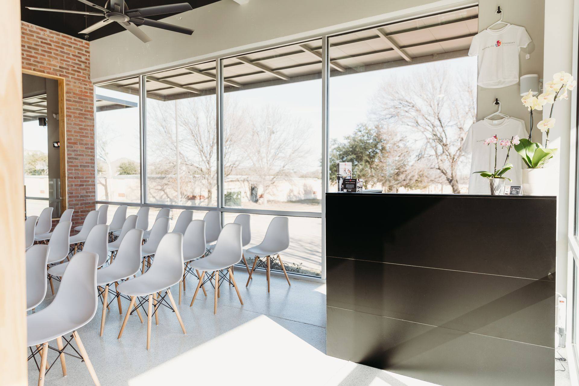 After: the finished reception desk and waiting seating along the storefront glazing at Kung Fu Academy of North Texas in McKinney, TX
