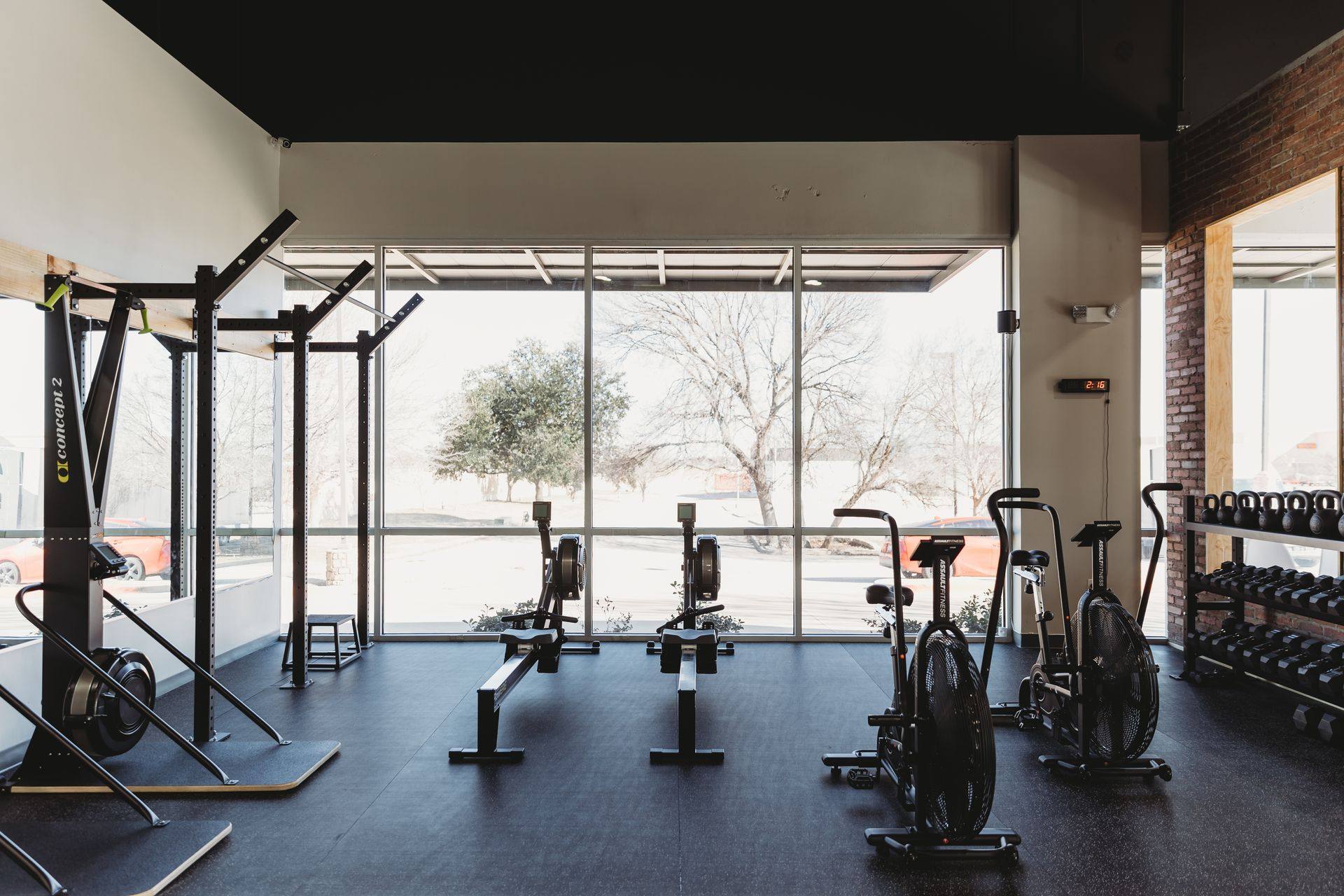 After: the finished conditioning area with rig, rowers and dumbbell rack against the storefront glazing at Kung Fu Academy of North Texas in McKinney, TX